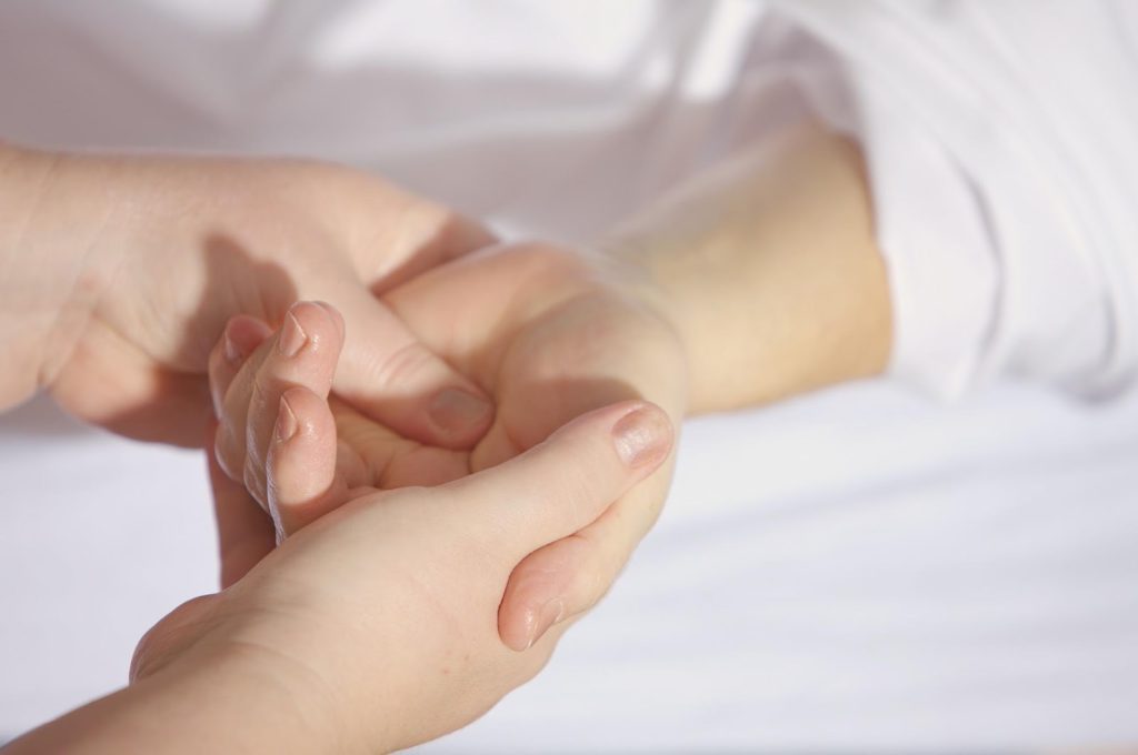 deux mains donnant un massage à la main d'une autre personne