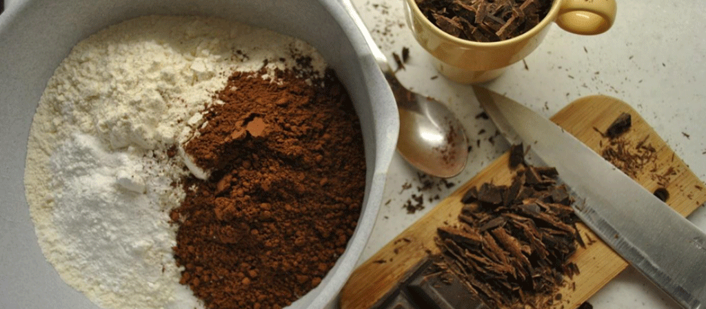 farine et poudre de cacao sur un bol, cannelle, un couteau et une cuillère