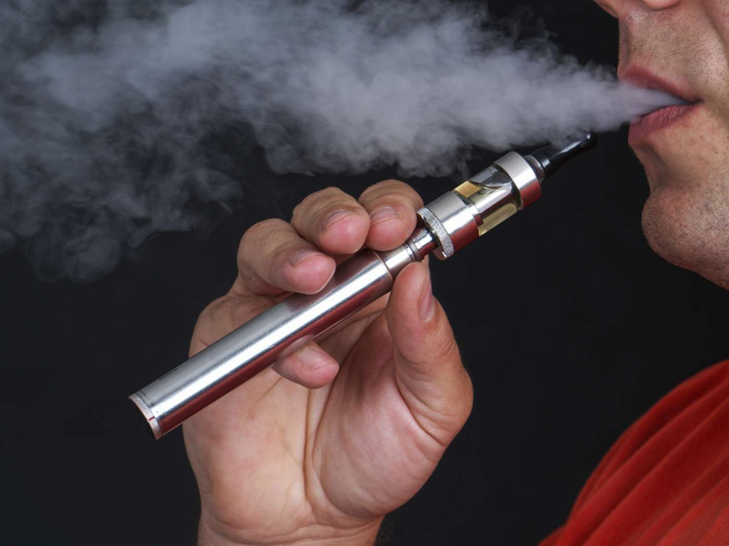 homme portant une chemise rouge à l'aide d'e-cigarette